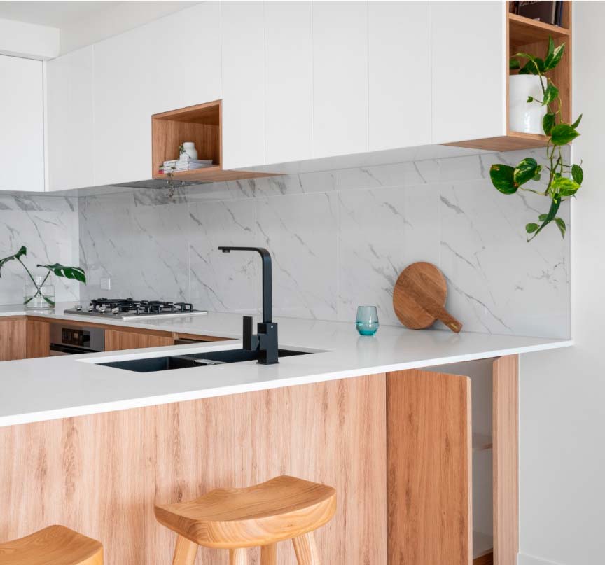 fotografía de cocina de color madera y blanca con un grifo negro